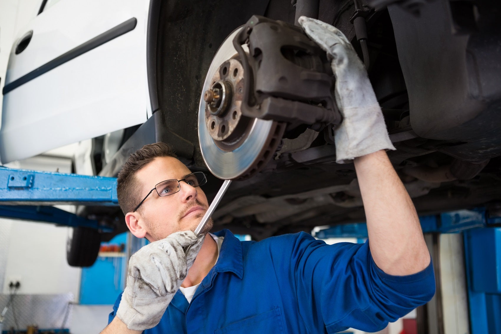 Technician Inspecting Car Brakes